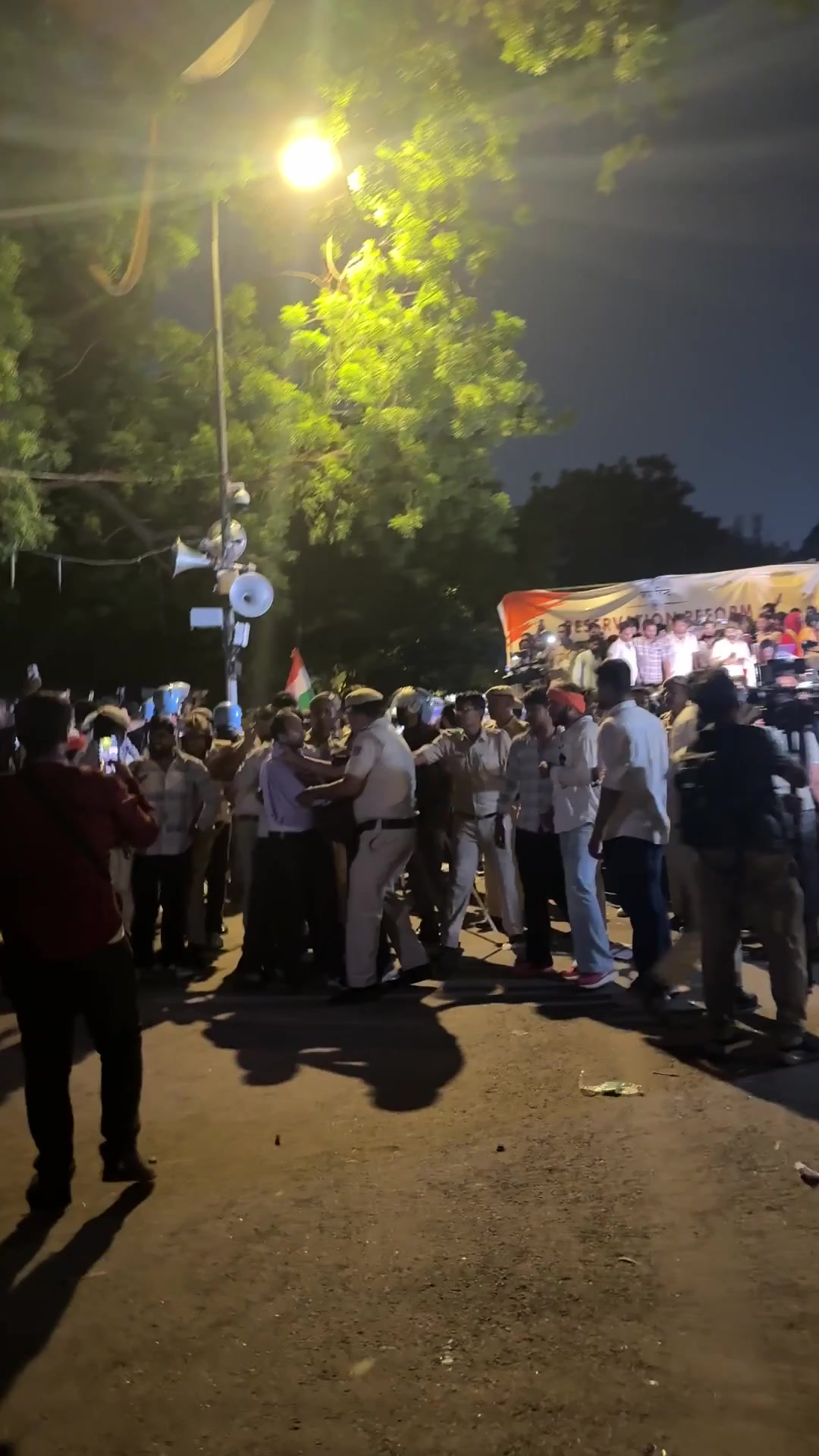 Nighttime gathering at Jantar Mantar with protesters and police personnel
